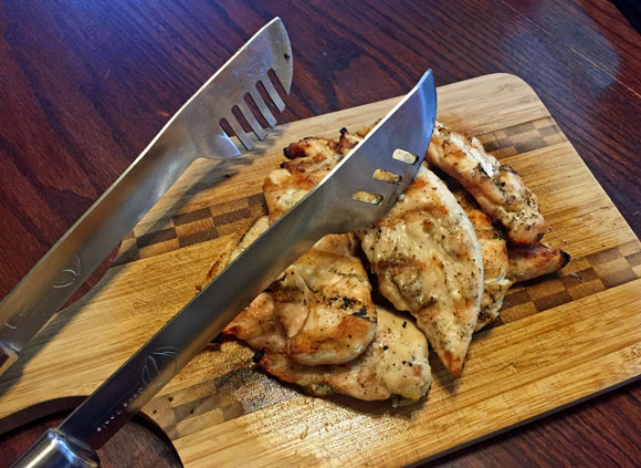 Grill Tongs with Chicken on Cutting Board