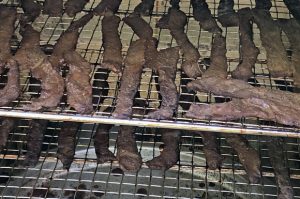 beef jerky on rack in smoker